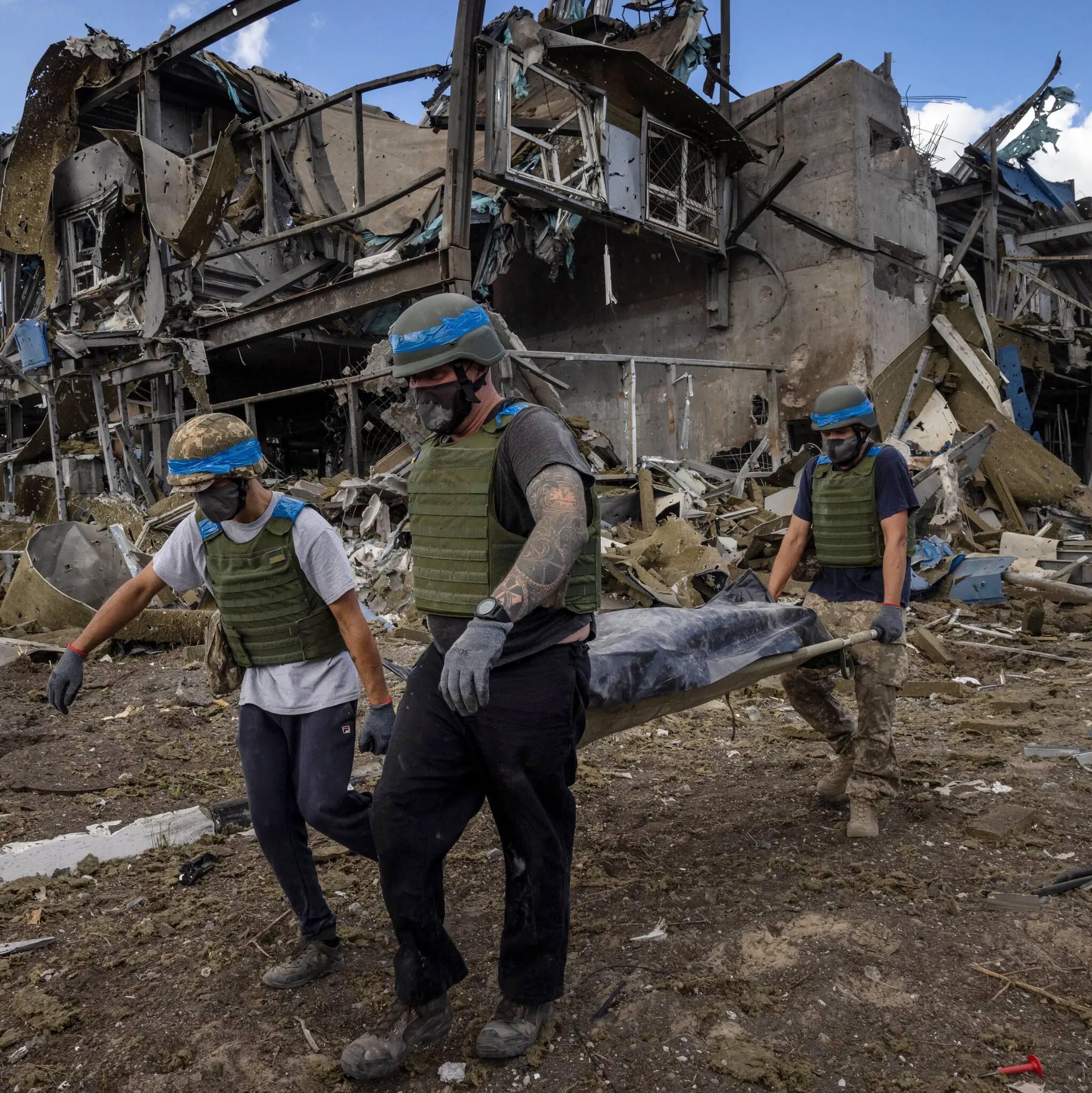 Українські чоловіки несуть загиблого російського солдата в Суджі, Росія